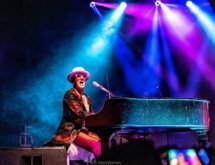 elton dan singing at the piano