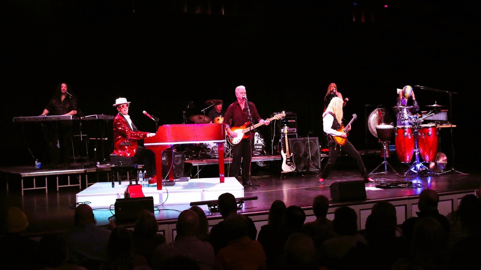 A nice landscape shot of the full band on stage. The first couple of rows of fans is visible.