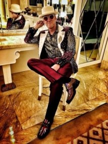 Elton Dan sitting in a very nice dressing room with marble floors and counter.