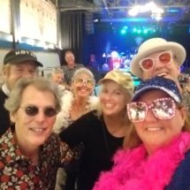 Dan and band posing with fans after a show. The stage is in the background.